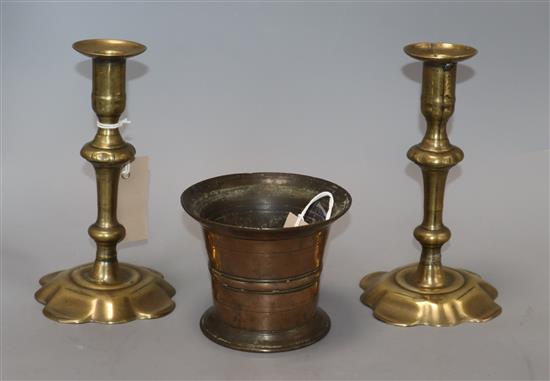 An 18th century bronze mortar and a pair of 18th century brass candlesticks
